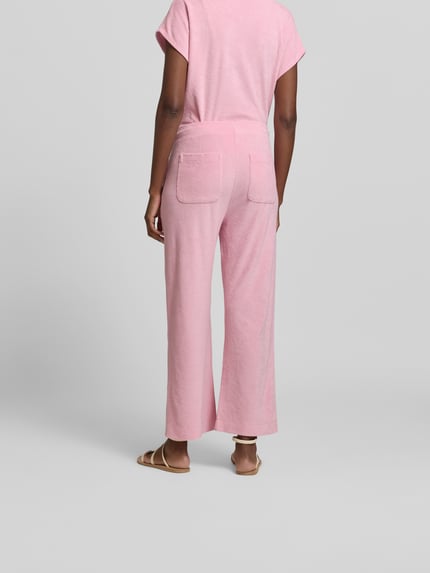 Vrouwenmodel draagt Culotte met elastische band van Juvia, katoenmix, flared fit, badstoflook, tunnelkoord, geheel roze, binnenbeenlengte 39 cm, bandwijdte 70 cm, full body back view.