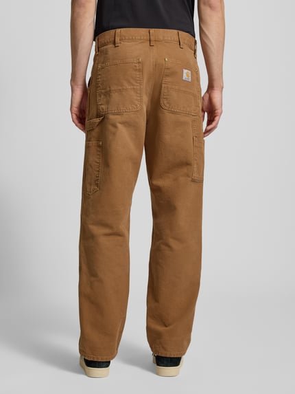 Männermodel trägt Cargohose im Used-Look von Carhartt Work In Progress aus brauner Bio-Baumwolle, lockerer Schnitt, Detailaufnahme Rückansicht.
