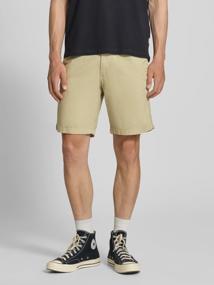 Männermodel trägt Shorts mit Tunnelzug Modell 'JAIDEN' von Jack & Jones aus Baumwoll-Leinen-Mix in Beige, Regular-Fit, Nahaufnahme Oberschenkel. Herren Shorts, Bundweite 43 cm, Innenbeinlänge 23 cm bei Größe M.