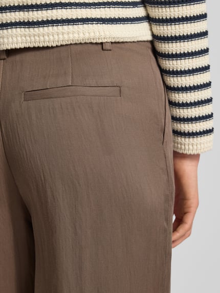 Kobiece modelka nosi Regular Fit Stoffhose aus Lyocell-Mix mit Viskose-Anteil od Fynch-Hatton, brązowy materiał, struktura gładka, detal logo, tylna kieszeń, kontekst: damskie spodnie z lyocellu z dodatkiem wiskozy, krój regular fit, zakładki w pasie, szerokość w rozmiarze 36: 40 cm, długość nogawki wewnętrznej: 78 cm, detal tylnej kieszeni, detal z tyłu, zbliżenie tylnej części.