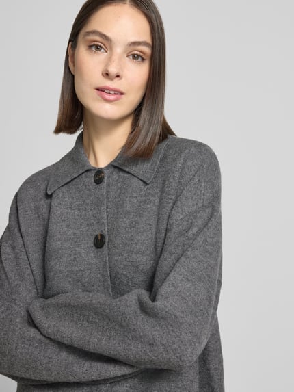 Frauenmodel trägt Cardigan aus Wolle mit Umlegekragen und Knopfleiste von Stefanel, graue Farbe, Relaxed Fit, Nahaufnahme Oberkörper.
