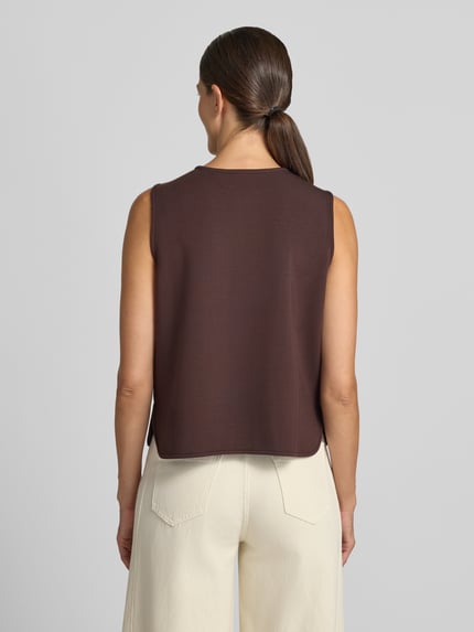 Frauenmodel trägt Regular Fit Weste aus Viskose-Mix Modell 'Josie' von VARLEY in Braun, glatte Textur, Damen Weste, Ganzkörperansicht Rückansicht.