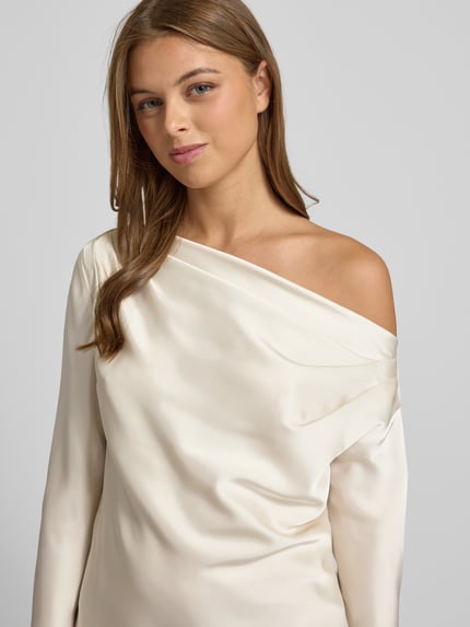 Frauenmodel trägt Regular Fit Bluse im One-Shoulder-Look Modell 'HASBRIN' von Lauren Ralph Lauren aus cremefarbenem Satin mit glatter Textur, Nahaufnahme Oberkörper. Rückenlänge bei Größe S: 52 cm, Ärmellänge: 63 cm.