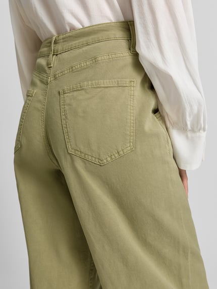 Frauenmodel trägt Barrel Fit Jeans aus Baumwoll-Mix von s.Oliver RED LABEL in hellem Olivgrün mit Gesäßtasche, Nahaufnahme Rückansicht.