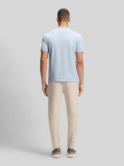 Männermodel trägt Regular Fit T-Shirt aus Baumwoll-Mix Modell 'TEE' von BOSS Green, Optik: Unifarben, Label-Print, Ganzkörperansicht Rückansicht.