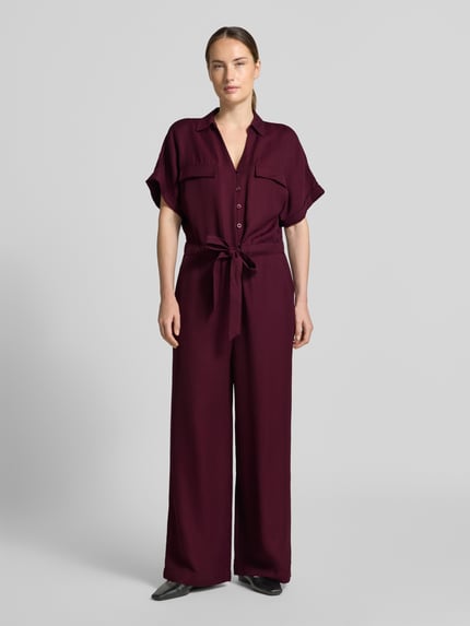 Frauenmodel trägt Jumpsuit aus Viskose-Lyocell-Mix von MORE & MORE in Dunkelrot, glatte Textur, taillierte Passform, Ganzkörperansicht von vorne.