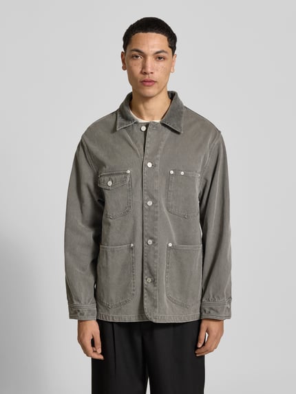 Männermodel trägt Strickjacke aus Alpaka Wolle von Officine Générale in grauem Used Look Denim mit sichtbaren Nähten, Ganzkörperansicht von vorne.