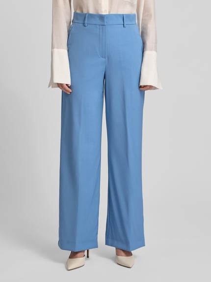 Modelka nosi Regular Fit Bundfaltenhose aus reiner Schurwolle Modell 'VISIVO' od Weekend Max Mara, jasnoniebieska, gładka wełna, widok z przodu, cała sylwetka.