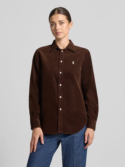 Frauenmodel trägt Regular Fit Hemdbluse aus reiner Baumwolle von Polo Ralph Lauren in Dunkelbraun mit sichtbarer Knopfleiste und Logo, Ganzkörperansicht von vorne. Damen Hemdbluse von Polo Ralph Lauren.