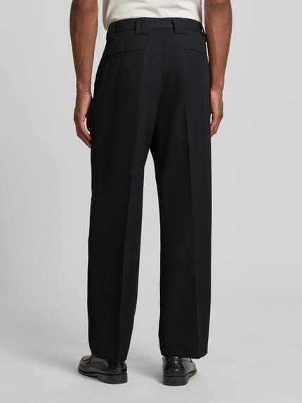 Männermodel trägt schwarze Stoffhose mit Bügelfalten und Eingrifftaschen von MCNEAL, Material-Mix mit Viskose-Anteil, Ganzkörperansicht Rückansicht.