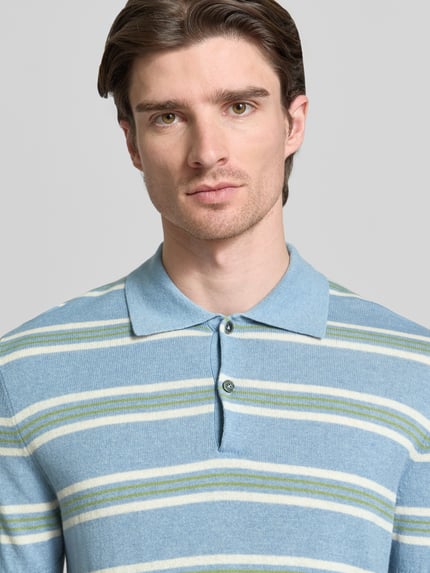 Männermodel trägt 'Poloshirt aus Baumwoll-Lyocell-Mix mit Kaschmir-Anteil mit gerippten Abschlüssen' von FTC-Cashmere, Regular Fit, polokragen, korte knoopsluiting, lichtblauw met groene en witte strepen, katoenen-Lyocell-mix met kasjmier, Nahaufnahme Oberkörper.