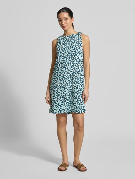Frauenmodel trägt Relaxed Fit Midikleid aus reiner Viskose von ZABAIONE, blau mit weißem Muster, U-Boot-Ausschnitt, Falten-Optik, Ärmelloses-Design, Rückenlänge 82 cm, Brustweite 50 cm, Ganzkörperansicht von vorne.