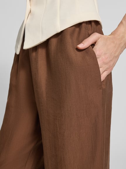 Frauenmodel trägt Wide-Leg-Pants mit elastischem Bund und Kordelzug von Rich & Royal, Lyocell-Mix, Loose-Fit, Detailaufnahme rechter Hüftbereich.