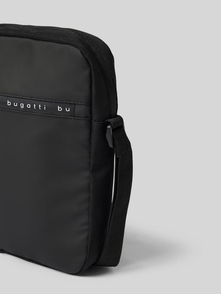Produktfoto, czarna Umhängetasche mit Label-Details Modell 'Blanc Delight' von bugatti, struktura materiału, kontekst: torba męska, główna komora na zamek, regulowany pasek na ramię, szerokość w rozmiarze 1: 21 cm, długość w rozmiarze 1: 26 cm, głębokość w rozmiarze 1: 5 cm, długość paska w rozmiarze 1: 118 cm