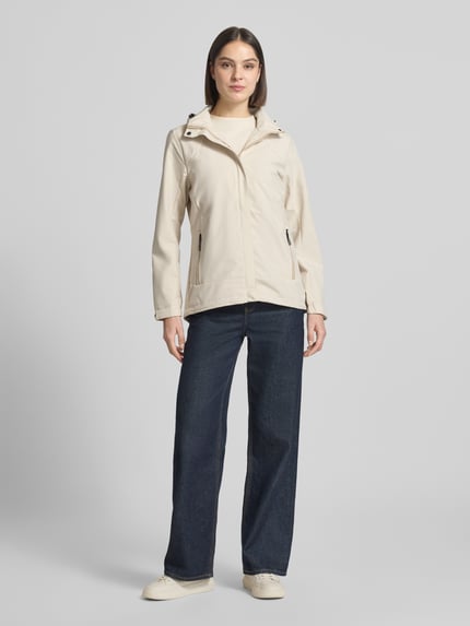 Frauenmodel trägt Parka mit Kapuze und verdecktem Reißverschluss von G.I.G.A. DX in Beige, mit Label-Patch und seitlichen Reißverschlusstaschen, Gerader-Schnitt, wasserabweisend, Ganzkörperansicht von vorne. Rückenlänge bei Größe 36: 70 cm, Schulterbreite: 41 cm, Brustweite: 51 cm, Ärmellänge: 63 cm.