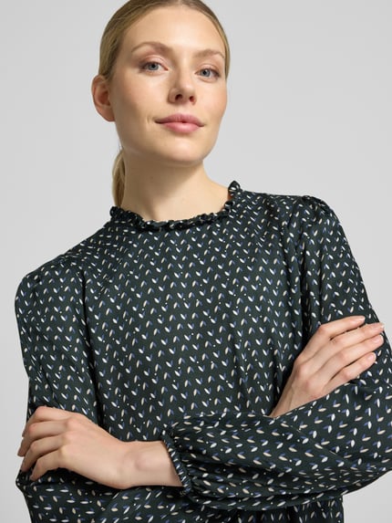 Vrouwenmodel draagt Bluse aus Viskose mit Rundhalsausschnitt und Rüschen van MORE, donkerkleurige print, zuiver viscose, straight fit, ronde hals met ruches, elastische boorden, ruglengte maat 36: 52 cm, mouwlengte maat 36: 63 cm, Nahaufnahme bovenlichaam.