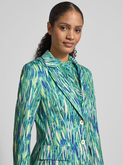 Frauenmodel trägt Slim Fit Blazer im Allover-Look von Marc Cain, Material-Mix mit Stretch-Anteil, Reverskragen, Knopfverschluss, Pattentaschen, Nahaufnahme Oberkörper.