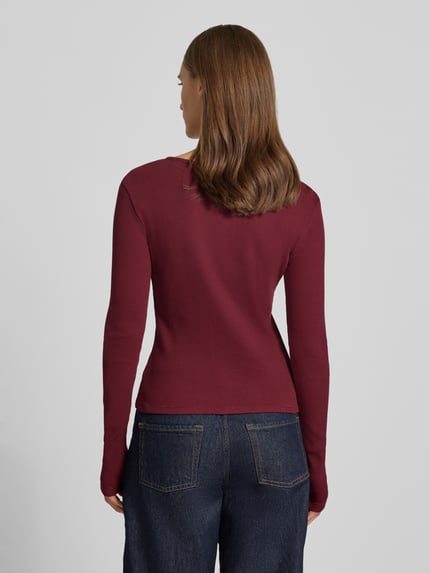 Frauenmodel trägt Slim Fit Langarmshirt aus reiner Baumwolle von REVIEW in Dunkelrot, strukturierte Oberfläche, Rückenansicht, Damenmode.