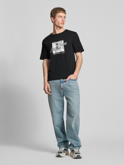 Męski model nosi T-Shirt mit Rundhalsausschnitt Modell 'HONOLULU' von Jack & Jones z nadrukiem, czarny kolor, bawełna, krój regular fit, kompletna sylwetka z przodu