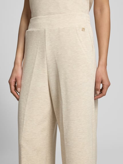 Vrouwenmodel draagt sweatpants uit viscosemix met stretch, wide leg fit, elastische band, steekzakken, labeldetail, model 'Namara' van MOS MOSH, binnenbeenlengte maat S 69 cm, detailopname bovenbeen.