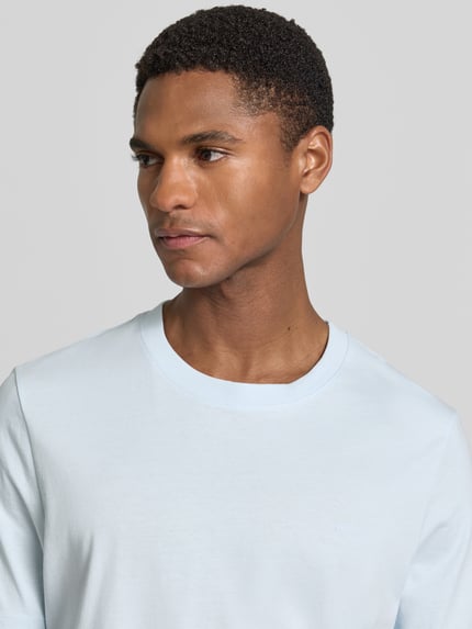 Männermodel trägt Regular Fit T-Shirt aus reiner Baumwolle von s.Oliver RED LABEL, Optik: Unifarben, Label-Schriftzug, Nahaufnahme Oberkörper