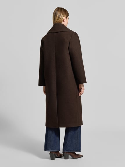 Frauenmodel trägt Regular Fit Mantel aus Woll-Mix Modell 'FOUZ' von Cph Muse in Dunkelbraun, klare Linien, Rückenansicht, Ganzkörperansicht Rückansicht. Mantel mit Knopfverschluss und Pattentaschen, Rückenlänge 122 cm, Schulterbreite 44 cm, Brustweite 56 cm, Ärmellänge 62 cm.
