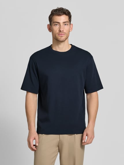 Männermodel trägt T-Shirt mit Logo-Print und Rundhalsausschnitt von Profuomo aus Reine Bio-Baumwolle, Relaxed-Fit, dunkles Blau, Ganzkörperansicht von vorne. Rückenlänge bei Größe M: 70 cm.