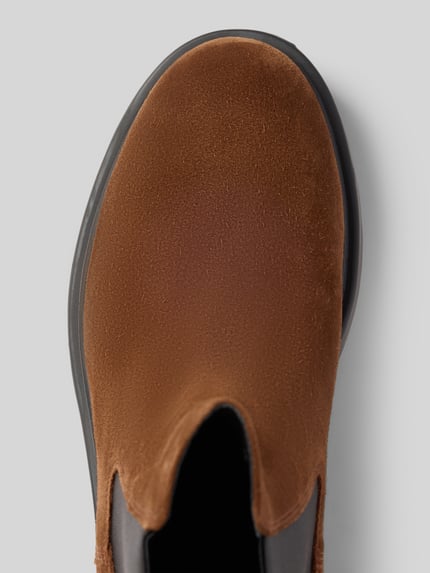 Productfoto, Boots uit echt leer Model 'Dean' van Camper, afgeronde pasvorm, logo detail, bruin met zwarte zool, textuur glad, context: herenboots, hakhoogte 3 cm, schachthoogte 15 cm, schachtwijdte 13 cm.