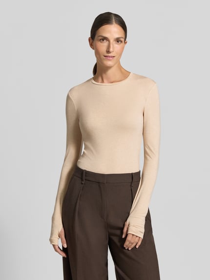 Modelka nosi Slim Fit Longsleeve aus elastischem Woll-Mix von Stefanel, beżowy melanż, długi rękaw, krój slim fit, okrągły dekolt, długość tyłu 60 cm w rozmiarze S, widok całej sylwetki z przodu.