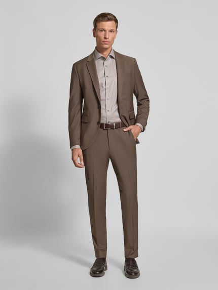 Männermodel trägt Slim Fit Businesshemd mit Kentkragen Modell 'Savio' von OLYMP SIGNATURE in Hellgrau zu braunem Anzug, Baumwolle, Ganzkörperansicht von vorne.