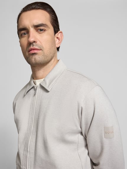 Männermodel trägt Regular Fit Sweatjacke aus Baumwoll-Mix Modell 'PE_TWIST' von BOSS Orange, Optik: Unifarben, Nahaufnahme Oberkörper.