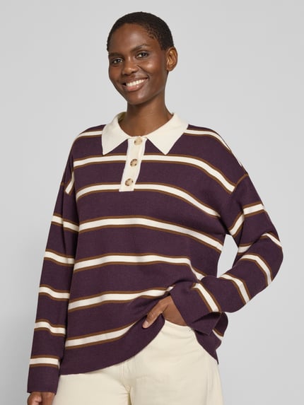 Frauenmodel trägt Relaxed Fit Strickpullover aus Viskose-Mix Modell 'ISABELL' von YAS, lila mit beigen Streifen, Polokragen, Ganzkörperansicht von vorne.