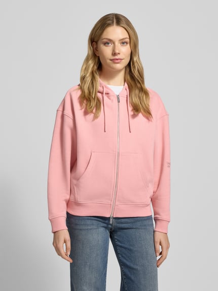Frauenmodel trägt Oversized Sweatjacke mit Kapuze von Smith and Soul in Rosa, Baumwoll-Mix, Reißverschluss, Eingrifftaschen, Ganzkörperansicht von vorne.