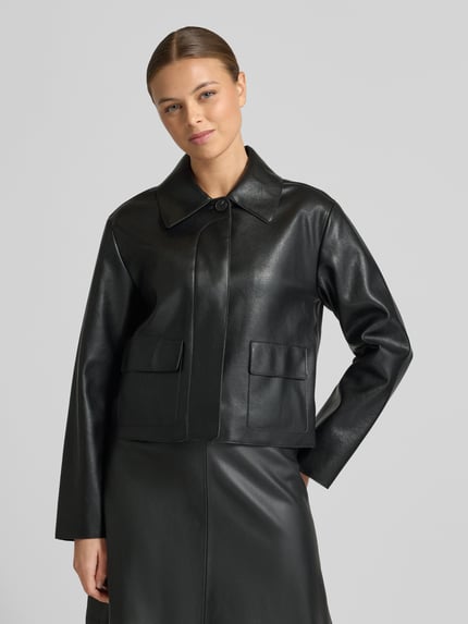 Frauenmodel trägt Jacke in Leder-Optik Modell 'SABINA' von Mango, Regular-Fit, Hemdblusenkragen, Knopfleiste, Pattentaschen, Nahaufnahme Oberkörper