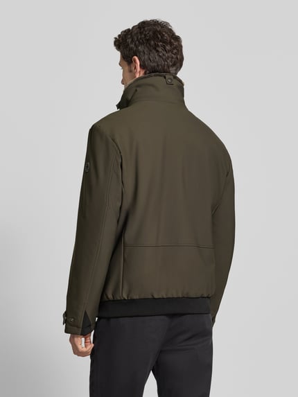 Männermodel trägt Daunenjacke mit abnehmbarem Kapuzeneinsatz von Strellson in matt-oliv, strukturierte Webware, Rückansicht, Ganzkörperansicht.