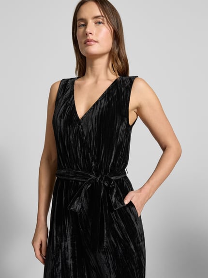 Frauenmodel trägt Regular Fit Jumpsuit aus Samt von Tom Tailor Denim in Schwarz mit V-Ausschnitt, Gürteldetail, Nahaufnahme Oberkörper.