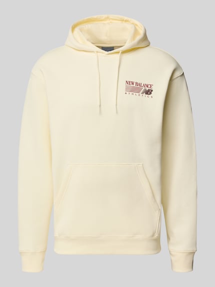 Produktfoto, Relaxed Fit Hoodie aus Baumwoll-Mix Modell 'REIMAGINED' von New Balance in Hellgelb mit Kapuze, Känguru-Tasche und Label-Detail