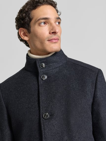 Männermodel trägt Wollmantel Modell 'MAICO' mit Stehkragen von JOOP!, unifarben, strukturierte Oberfläche, Nahaufnahme Oberkörper.