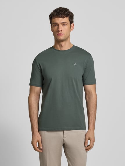 Männermodel trägt T-Shirt mit Label-Print von MARC O'POLO in Unifarbenes-Design, Reine Baumwolle, Gerader-Schnitt, Rundhalsausschnitt, Label-Detail, Rückenlänge 69 cm bei Größe M, Ganzkörperansicht von vorne.