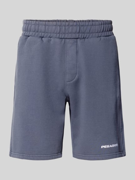 Produktfoto, Shorts mit elastischem Bund und Logo-Stitching von Pegador aus Baumwoll-Mix in Grau, Loose-Fit, französische Eingrifftaschen, Bundweite 38 cm, Innenbeinlänge 23 cm.