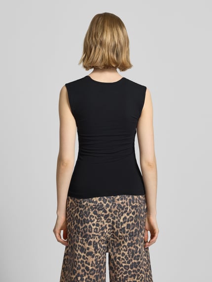 Frauenmodel trägt schwarzes Damen Top mit Karree-Ausschnitt Modell 'ISABELLA GIGI' von JJXX aus Baumwoll-Mix mit Stretch-Anteil, Rückansicht.