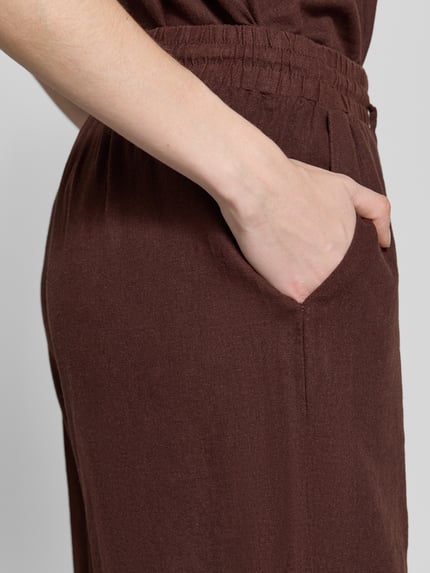 Kobieta nosi Leinenshorts mit elastischem Bund Modell 'Lava' von FREE/QUENT, mieszanka lnu i wiskozy, krój loose fit, wpuszczane kieszenie, troki, kontekst: damskie szorty, szerokość w rozmiarze S: 39 cm, długość wewnętrzna nogawki: 50 cm, zbliżenie boczne na kieszeń.