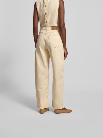 Vrouwenmodel draagt Straight Fit Jeans met siernaden van BAUM & PFERDGARTEN in katoenmix, lichte kleur, 5-pocketmodel, knoop- en ritssluiting, binnenbeenlengte maat 27: 80 cm, bandwijdte maat 27: 39 cm. Ganzlichaamsaanzicht achteraan.