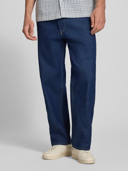 Männermodel trägt Loose Fit Jeans im 5-Pocket-Design Modell 'EDDIE' von JACK & JONES aus reiner Baumwolle, dunkelblauer Stoff, Nahaufnahme Unterkörper, Vorderansicht.