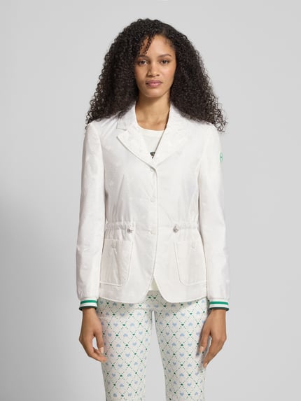 Vrouwenmodel draagt Regular Fit Blazer mit opgestikte zakken van Marc Cain met all-over motiefprint, reverskraag, logo-applicatie, tunnelkoord, doorlopende knoopsluiting, getailleerde pasvorm in regular fit, witte kleur met subtiele textuur, frontaal aanzicht, Ganzkörperansicht von vorne.