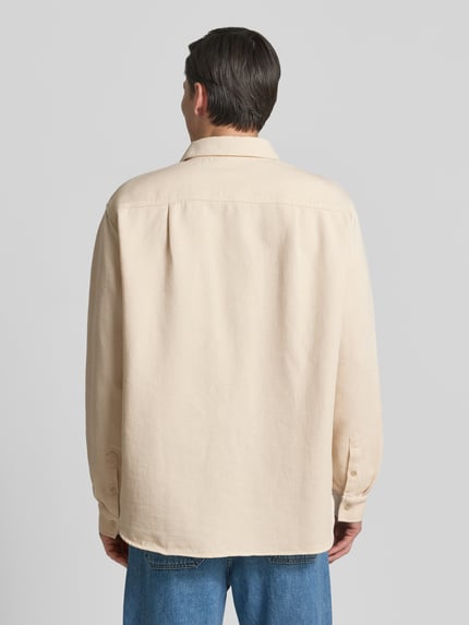 Männermodel trägt Regular Fit Freizeithemd mit Label-Patch von American Vintage aus Reine Baumwolle in Beige, Rückenlänge 77 cm, Schulterbreite 50 cm, Ärmellänge 66 cm, Kentkragen, Knopfleiste, Ganzkörperansicht Rückansicht.