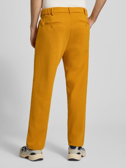 Männermodel trägt Straight Fit Chino mit Gesäßtaschen Modell 'SAMUEL' von CHILL PILL in Gelb, Baumwoll-Mix, Ganzkörperansicht Rückansicht.