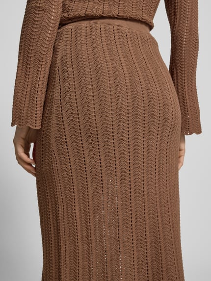 Frauenmodel trägt Strickrock mit elastischem Bund von Rich & Royal, Braun, Ajour-Strick, Straight Fit, Reine Baumwolle, blickdichter Unterrock, Nahaufnahme Rückansicht.