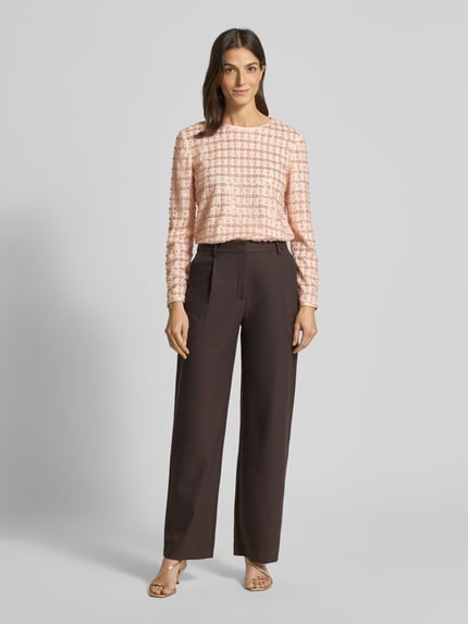 Frauenmodel trägt Blusenshirt mit Rundhalsausschnitt von Emporio Armani in lockerem Schnitt, zartes Rosa, strukturierte Oberfläche, Ganzkörperansicht von vorne.