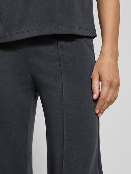 Vrouwenmodel draagt Hose aus Modal-Mix mit Längsnähten van Jake*s Collection, relaxed fit, elastische tailleband, antracietkleur, detailopname bovenbeen, context: dames broek, lengte binnenbeen 85 cm, taillewijdte maat S 39 cm.